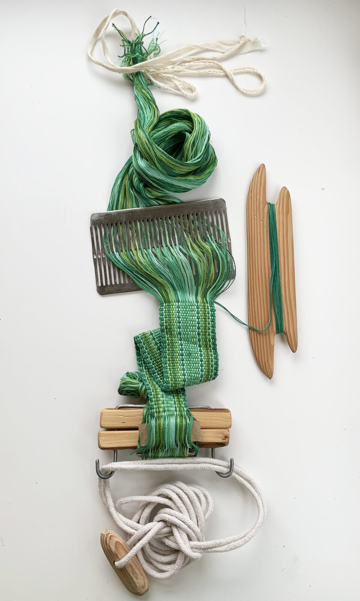 image shows a band of green weaving in progress.