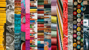 a colourful picture showing rows of coloured pencils, spools of coloured thread, red buttons, and similar creative elements