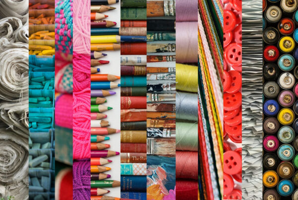 a colourful picture showing rows of coloured pencils, spools of coloured thread, red buttons, and similar creative elements